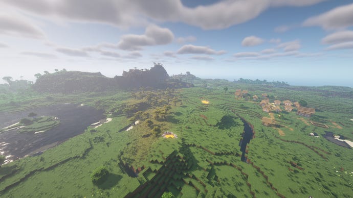 A Minecraft landscape of plains and rivers, with a village on the right and mountains on the left in the distance.