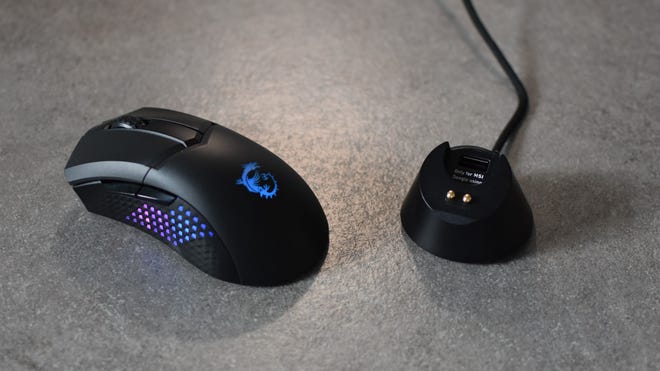 The MSI Clutch GM51 Lightweight Wireless next to its charging dock.